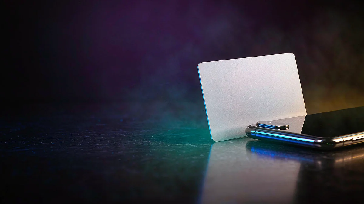 Blank card standing beside a smartphone